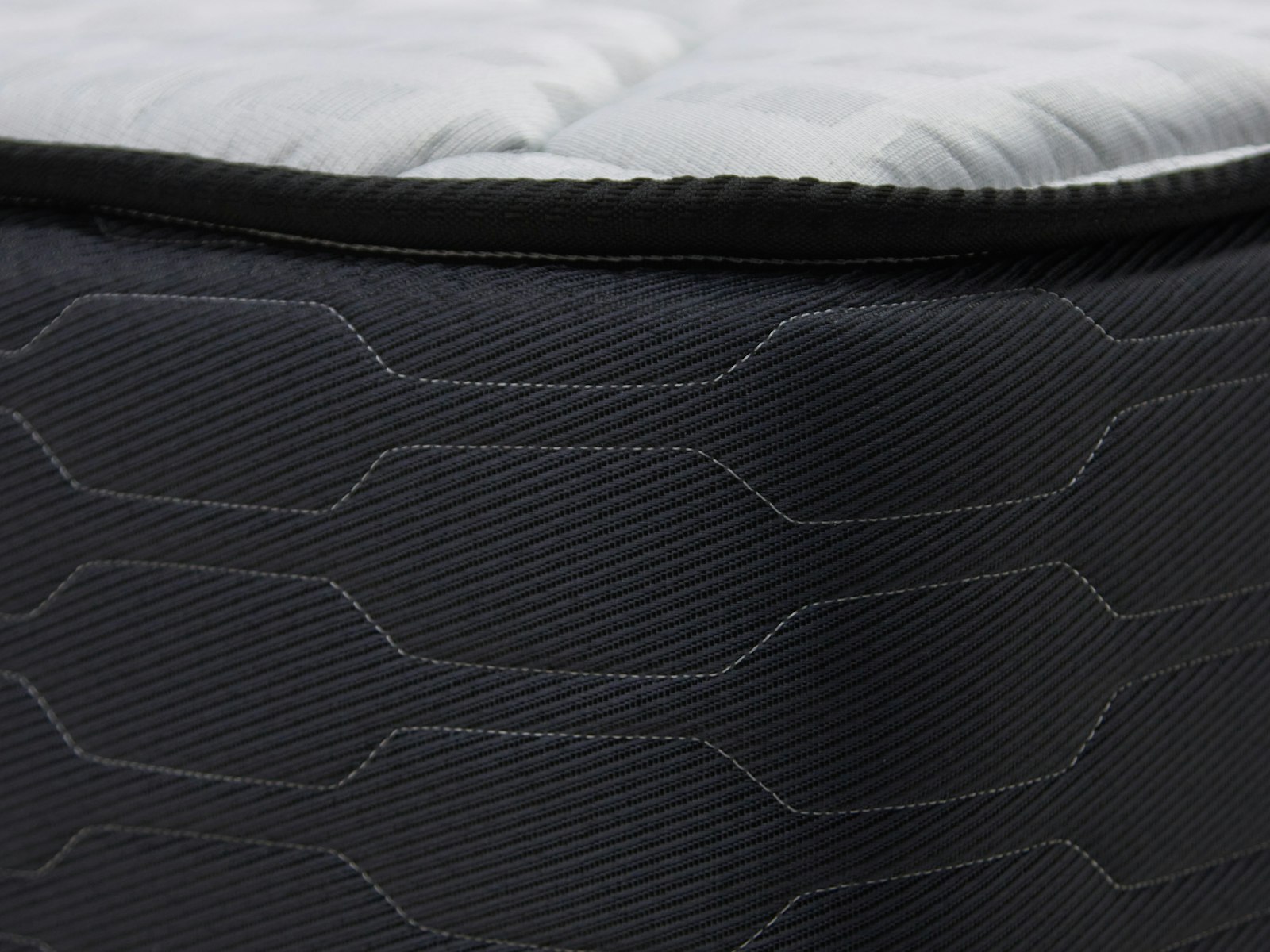 A close-up of a quilted mattress protected by a polythene cover